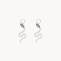 Front view of a pair of silver snake-shaped drop earring charms, each featuring a small marquise green tourmaline gemstone near the head and a textured silver body, set against a plain off-white background.