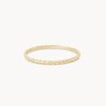 A delicate, thin gold ring with a subtle, intricate herringbone pattern engraved along its circumference, the revival stacking ring - 14k yellow gold by bluboho, set against a plain white background.
