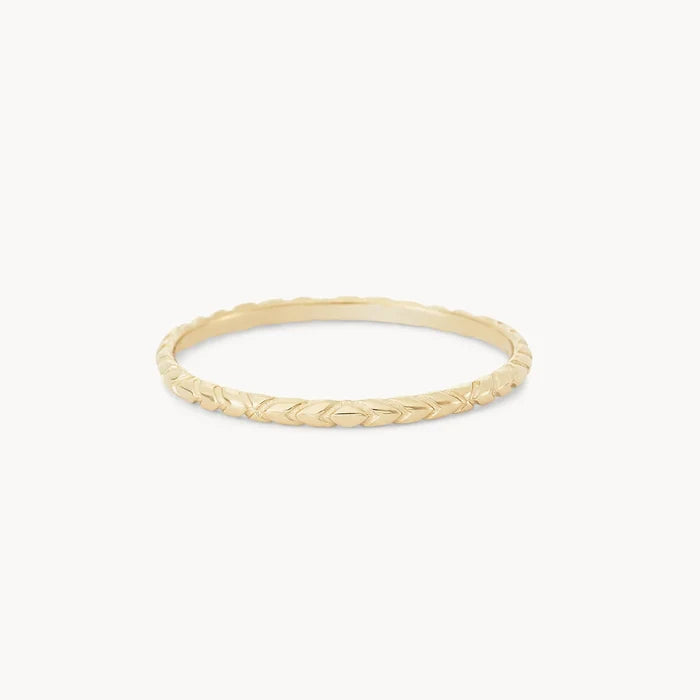 A delicate, thin gold ring with a subtle, intricate herringbone pattern engraved along its circumference, the revival stacking ring - 14k yellow gold by bluboho, set against a plain white background.