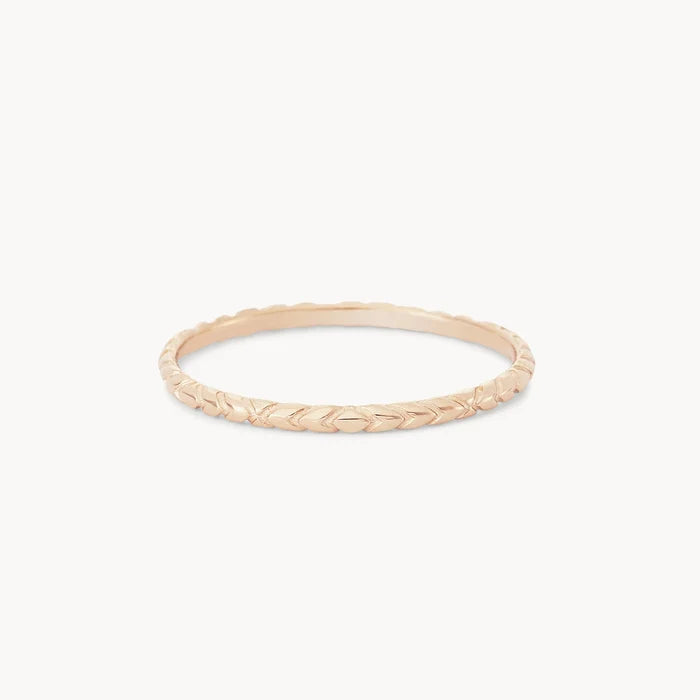 A delicate revival stacking ring - 14k yellow gold with a herringbone pattern design from bluboho. The band is thin and features a repeating V-shaped motif, giving it a textured and intricate appearance. The ring is displayed against a plain white background.