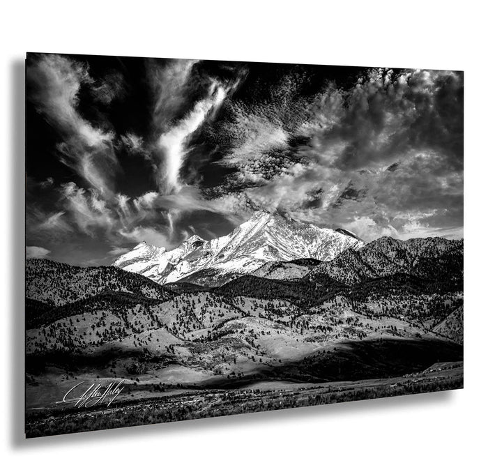 A majestic mountain range with snow-capped peaks and dramatic clouds in the sky, creating a striking and awe-inspiring landscape.