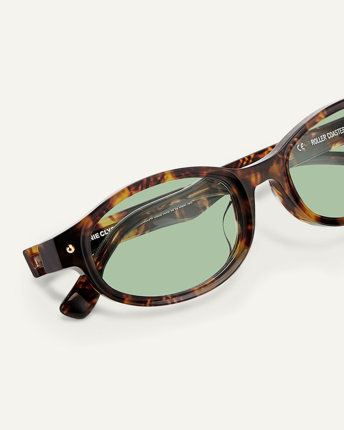 Close-up shot of Bonnie Clyde Roller Coaster sunglasses in tortoise with green lenses.