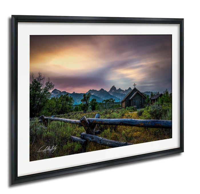 a serene rural landscape with a wooden fence, a small wooden building, and a mountain range in the background, all under a colorful sunset sky.
