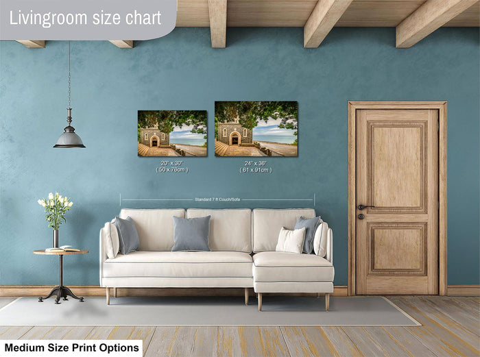 a living room with a white sofa, a wooden door, and a painting of a beach scene on the wall. The living room appears to be designed for relaxation and comfort, with a focus on the artwork and the overall aesthetic.