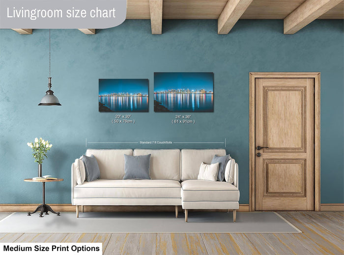 a living room with a white sofa, a wooden door, and a painting of a cityscape on the wall. The sofa is positioned in front of the painting, and the door is located to the right of the sofa. The painting is of a city skyline, and the sofa is white with gray pillows. The living room has a wooden floor and a wooden beam ceiling.