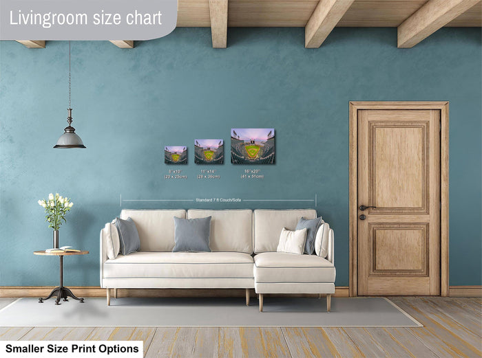 a living room with a white sofa, a wooden door, and a hanging light fixture. There are three framed artworks displayed on the wall, each with different sizes and dimensions. The living room appears to be well-decorated and spacious.