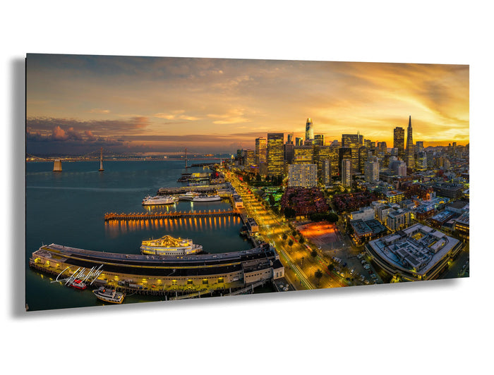 a vibrant cityscape at sunset, with a large body of water in the foreground and a skyline of tall buildings in the background. The city is illuminated by the warm glow of the setting sun, creating a picturesque and serene atmosphere.