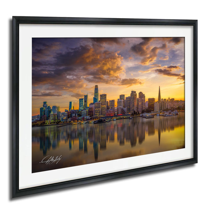 a city skyline at sunset, with the tall buildings reflected in the water below.