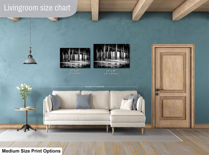 a living room with a white sofa, a wooden door, and a framed black and white photograph of a bridge hanging on the wall.