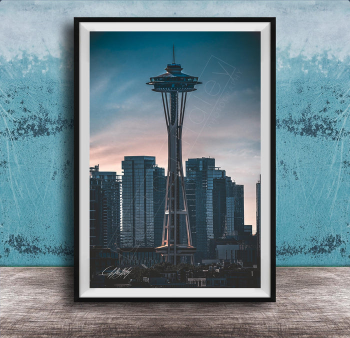 A framed photograph of the Space Needle, a famous landmark in Seattle, Washington, with the city skyline in the background.