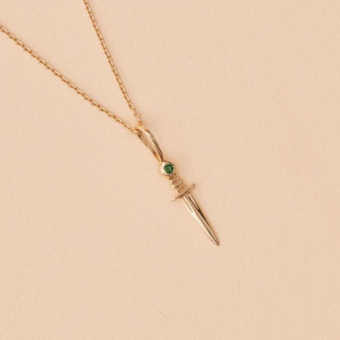 Small Dagger Charm with Emerald in 10k yellow gold, studio detail view
