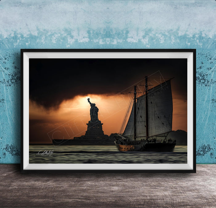a sailboat sailing on the water, with the Statue of Liberty in the background, against a dramatic sky with a sunset.
