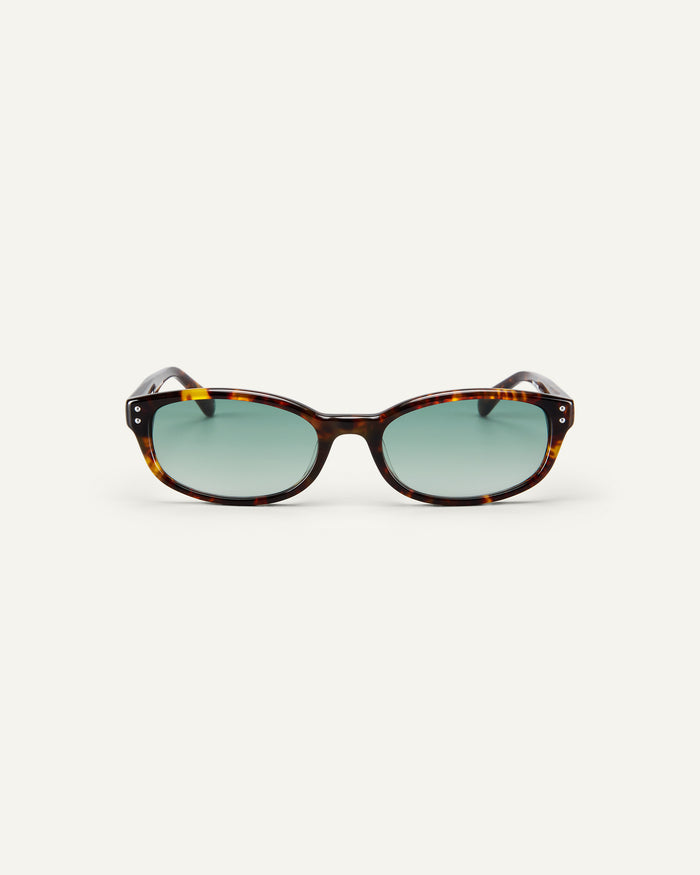 Face shot of Bonnie Clyde Sudoku sunglasses in tortoise with green lenses.