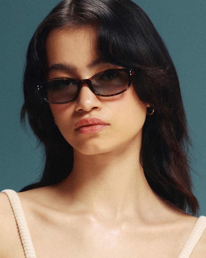 Quarter shot of Bonnie Clyde Sudoku sunglasses in tortoise with green lenses.