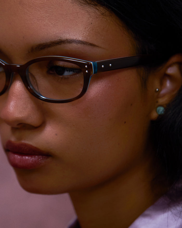 Close-up shot of Bonnie Clyde Sudoku optical frames in layered teal demi with clear lenses.
