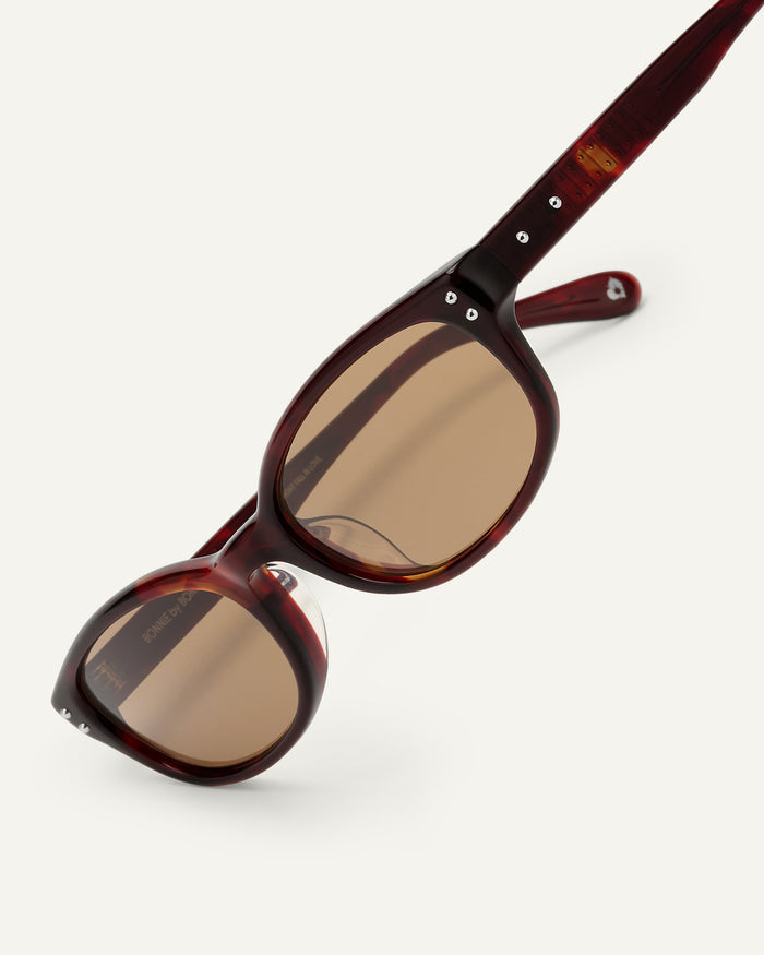 Close-up shot of Bonnie Clyde Sudoku sunglasses in red tortoise with brown lenses.