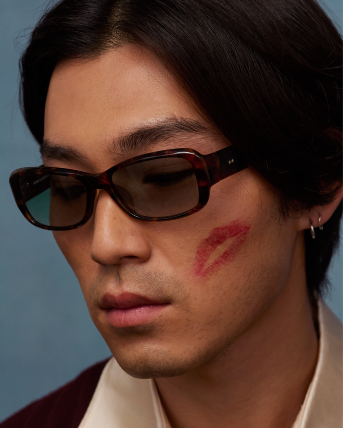 Quarter shot of Bonnie Clyde Sugar sunglasses in tortoise with green lenses.