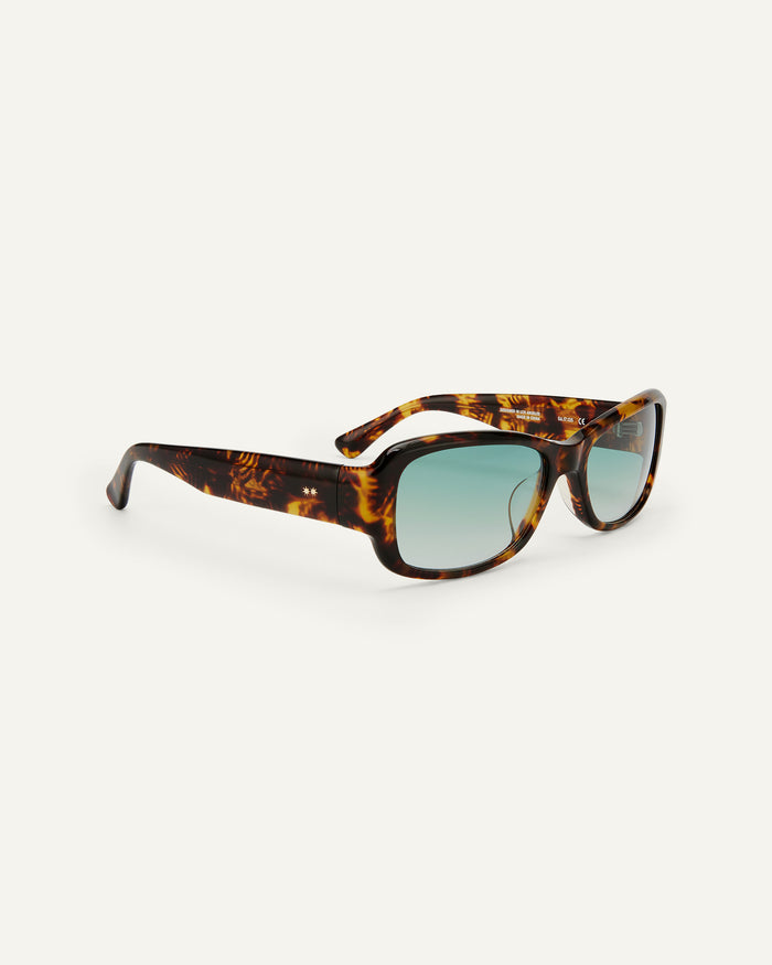 Side shot of Bonnie Clyde Sugar sunglasses in tortoise with green lenses.