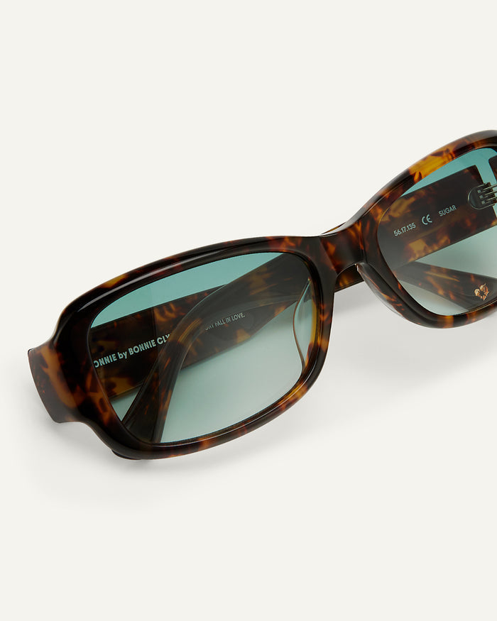 Close-up shot of Bonnie Clyde Sugar sunglasses in tortoise with green lenses.
