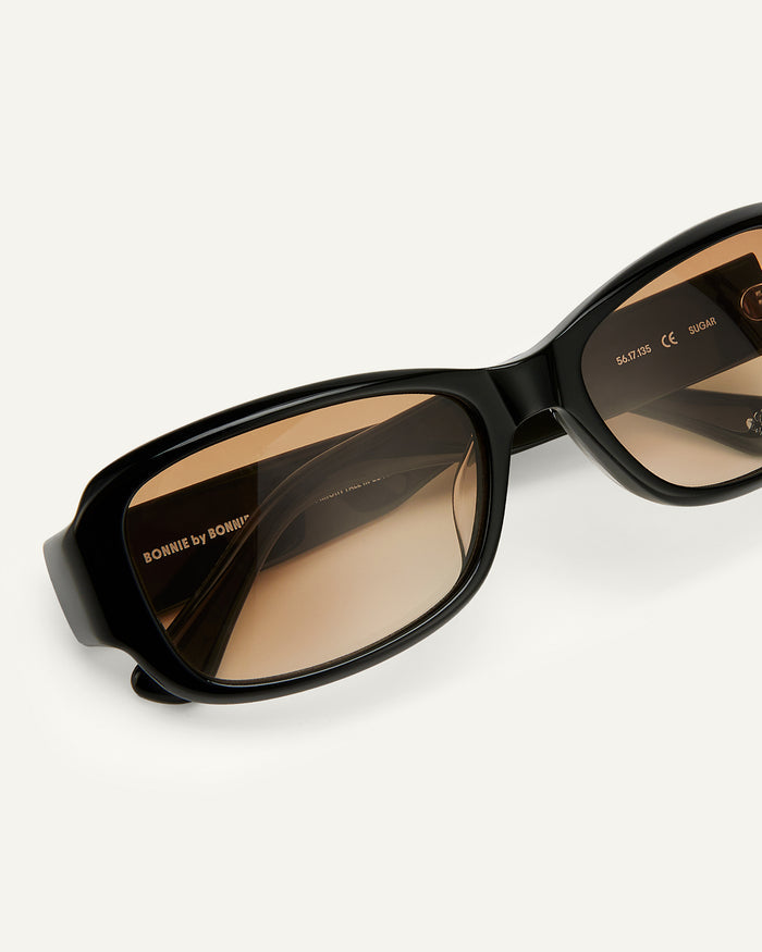 Close-up shot of Bonnie Clyde Sugar sunglasses in black with brown lenses.