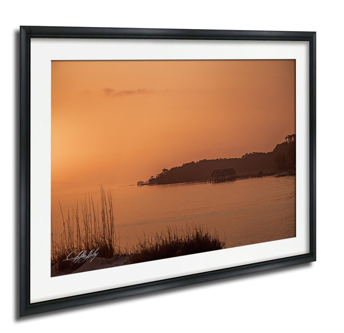 a serene sunset over a body of water, with a small island visible in the distance.