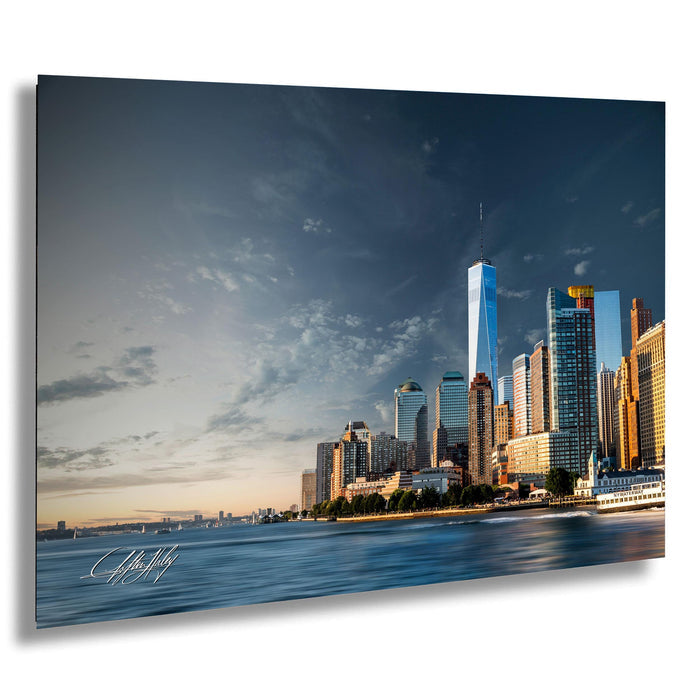 A panoramic view of the New York City skyline, with the One World Trade Center prominently visible among the surrounding skyscrapers. The sky is filled with clouds, creating a dramatic backdrop for the cityscape.
