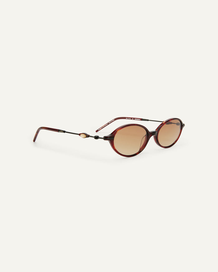 Close-up shot of Bonnie Clyde Swimming sunglasses in black and red tortoise with brown gradient lenses.