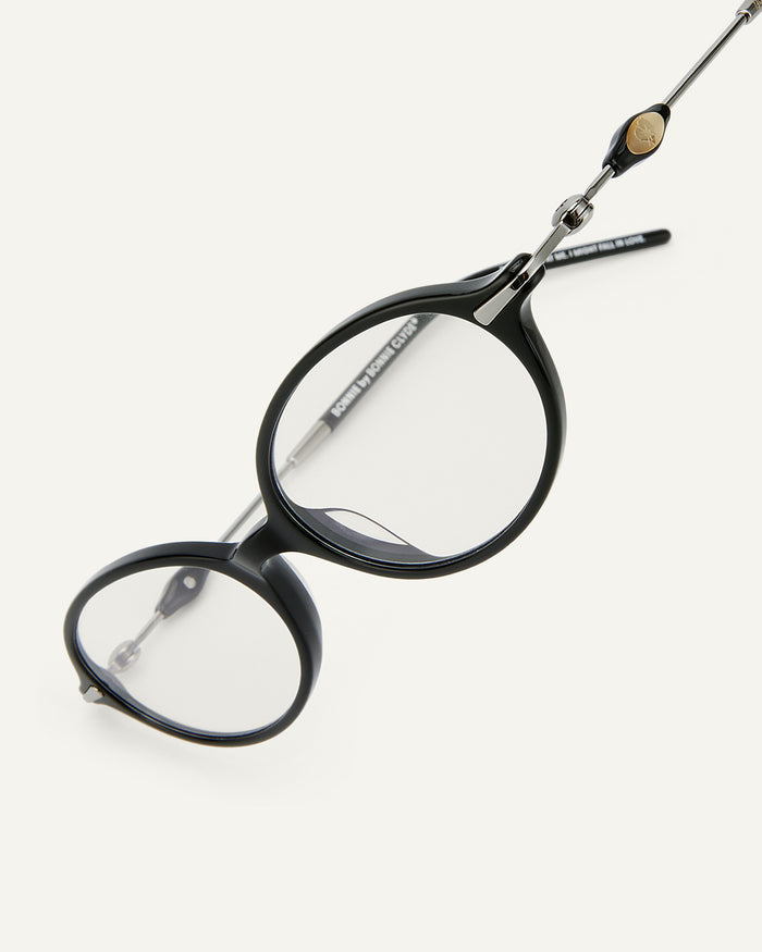Close-up shot of Bonnie Clyde Swimming optical frames in silver and black with clear lenses.