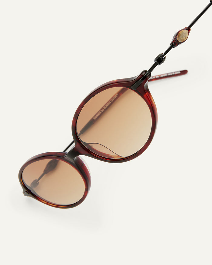 Detail shot of Bonnie Clyde Swimming sunglasses in black and red tortoise with brown gradient lenses.