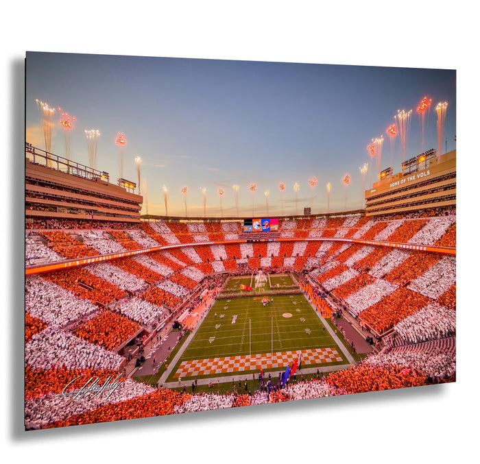 a large, brightly lit football stadium filled with spectators, with a checkered pattern of red and white on the field.