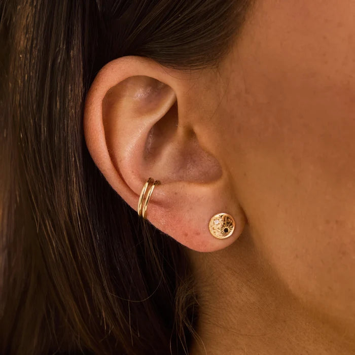 The Balance Within Yin Yang Earring in 14k yellow gold with black and white diamonds, shown worn on hand