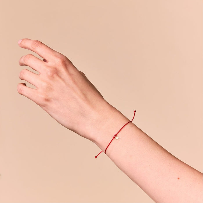 The Deep Love Contemplation Cord Bracelet in 10k yellow gold with red cord, alternate angle detail view 3