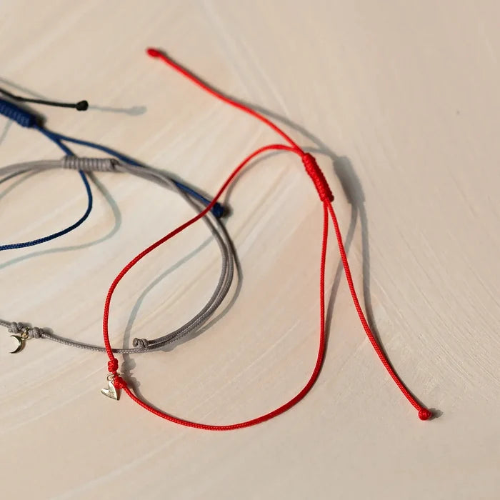 The Deep Love Contemplation Cord Bracelet in 10k yellow gold with red cord, alternate angle detail view 5