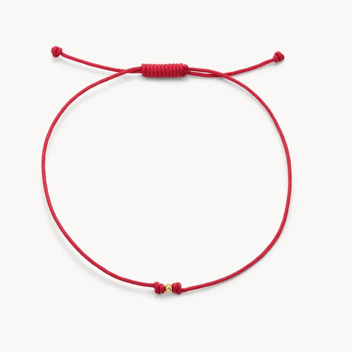 The One Cord Bracelet in 10k yellow gold with red cord