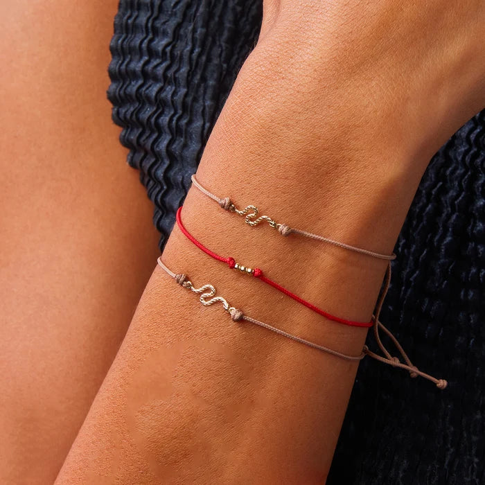 The Serpent Contemplation Cord Bracelet in 10k yellow gold with taupe cord, alternate angle detail view