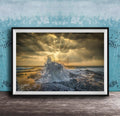 The image is a framed photograph of a dramatic ocean scene, with crashing waves and a dramatic sky filled with clouds and sunbeams.
