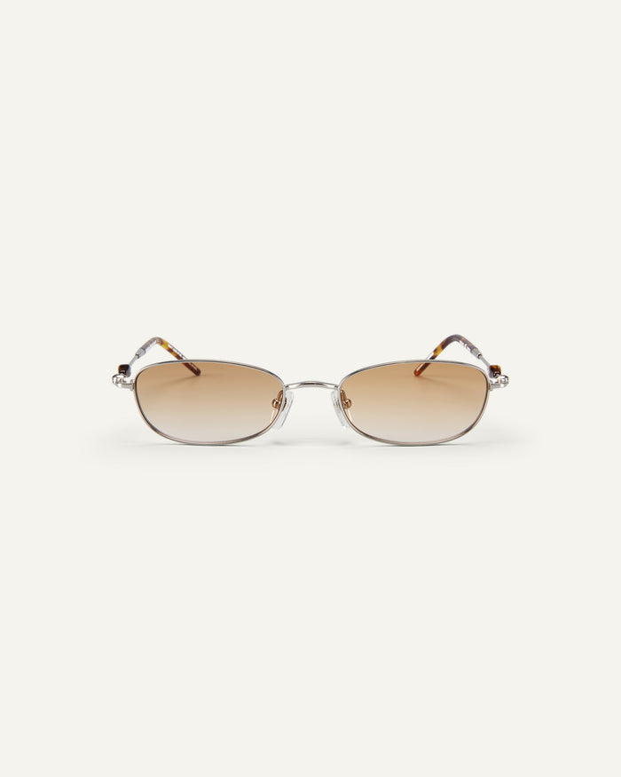 Face shot of Bonnie Clyde Tiptoe sunglasses in silver with brown lenses.