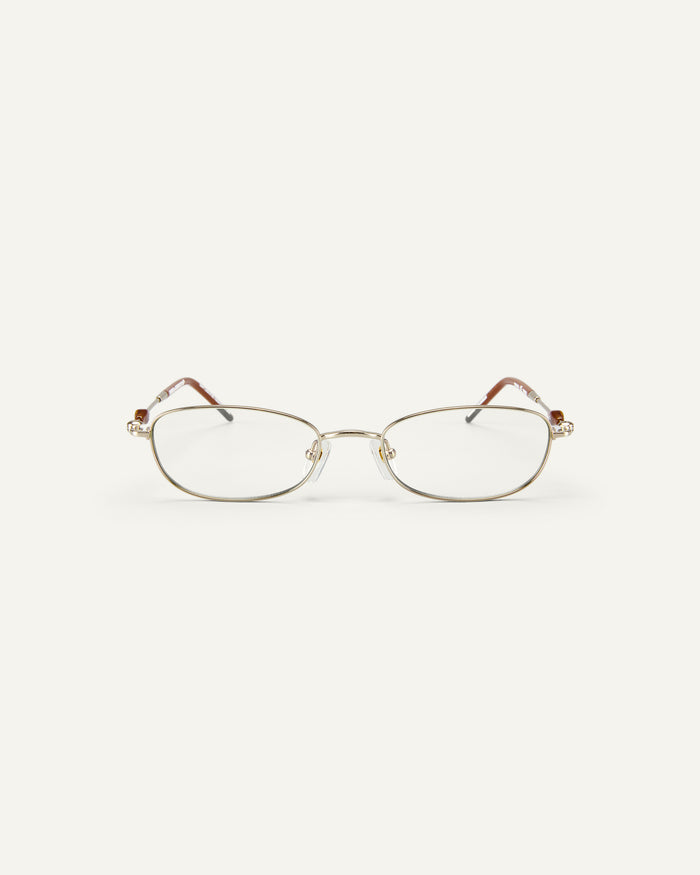 Face shot of Bonnie Clyde Tiptoe optical frames in gold with clear lenses.