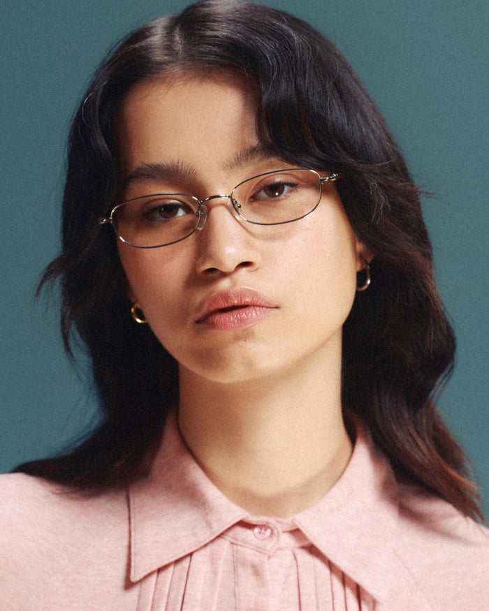 Quarter shot of Bonnie Clyde Tiptoe optical frames in gold with clear lenses.