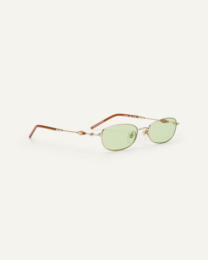 Side shot of Bonnie Clyde Tiptoe sunglasses in gold with green lenses.