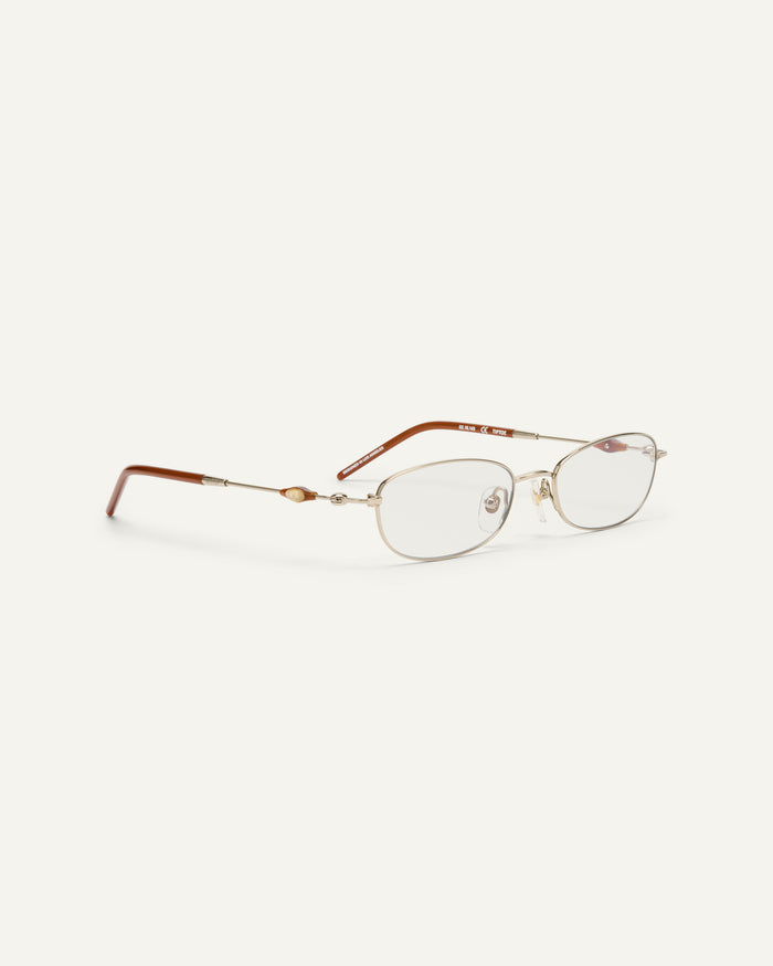 Side shot of Bonnie Clyde Tiptoe optical frames in gold with clear lenses.