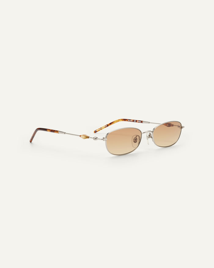Side shot of Bonnie Clyde Tiptoe sunglasses in silver with brown lenses.