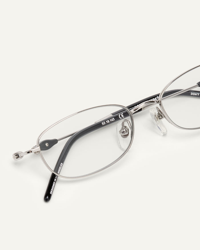 Detail shot of Bonnie Clyde Tiptoe optical frames in silver and black with clear lenses.