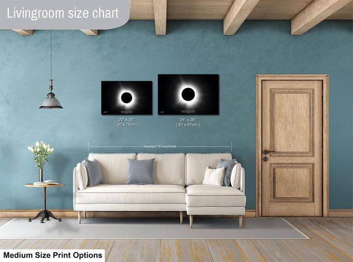 a living room with a white sofa, a wooden door, and a painting of a solar eclipse on the wall. The living room appears to be designed for relaxation and comfort, with a focus on the artwork and the overall aesthetic.