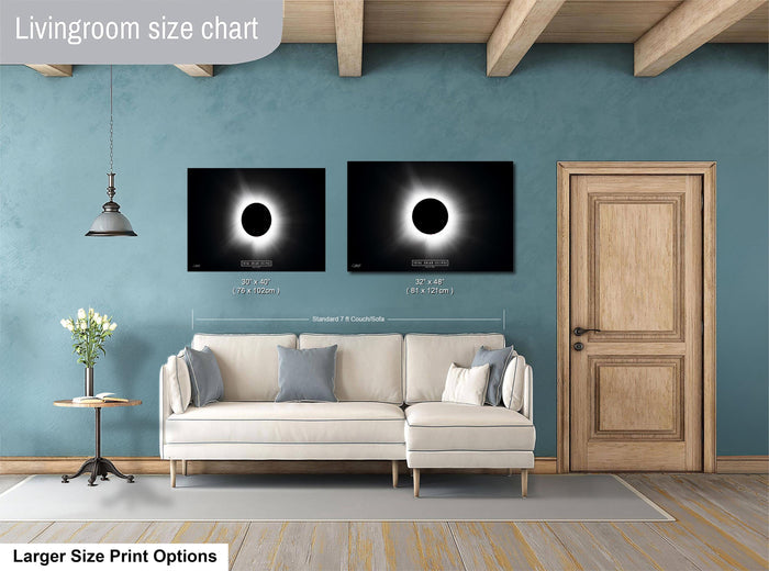 a living room with a white sofa, a wooden door, and two framed images of the solar eclipse on the wall.