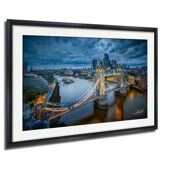 The image is a framed photograph of the London skyline at night, featuring the iconic Tower Bridge and the River Thames.