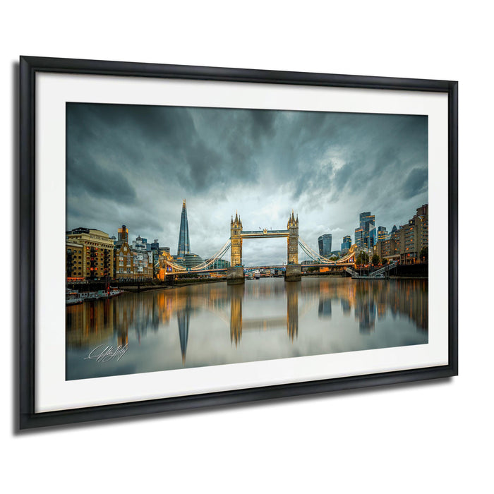 A framed photograph of the Tower Bridge in London, England, with the city's skyline and the River Thames in the background.