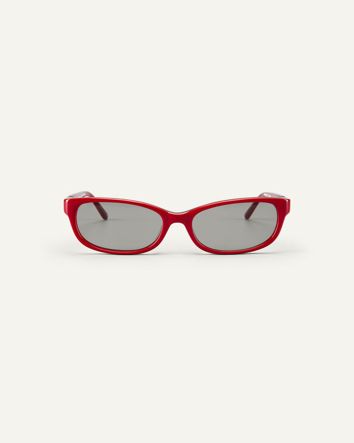 Face shot of Bonnie Clyde Trinket sunglasses in layered red with grey lenses.