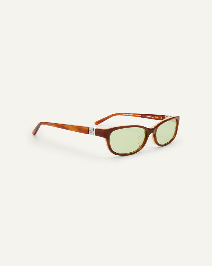 Quarter shot of Bonnie Clyde Trinket sunglasses in layered brown tortoise with green lenses.