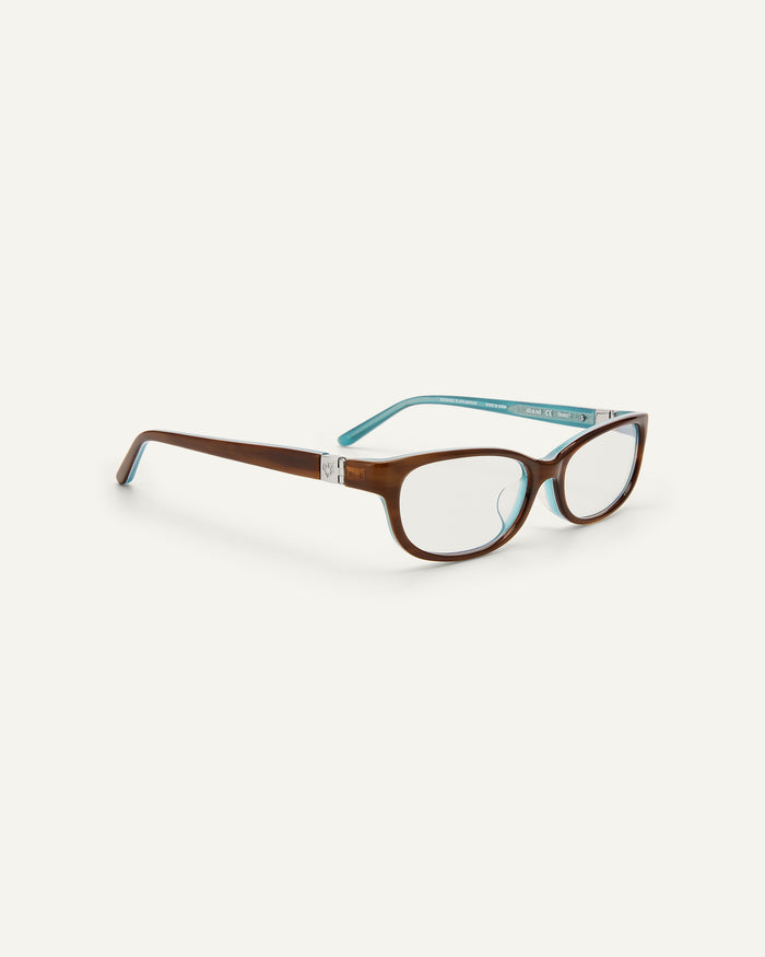 Quarter shot of Bonnie Clyde Trinket sunglasses in layered teal demi with clear lenses.